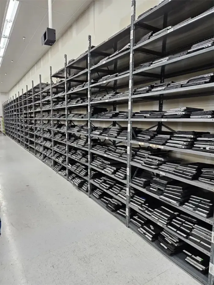 Long shelves of refurbished laptops, stacked and labelled, waiting for their next users.